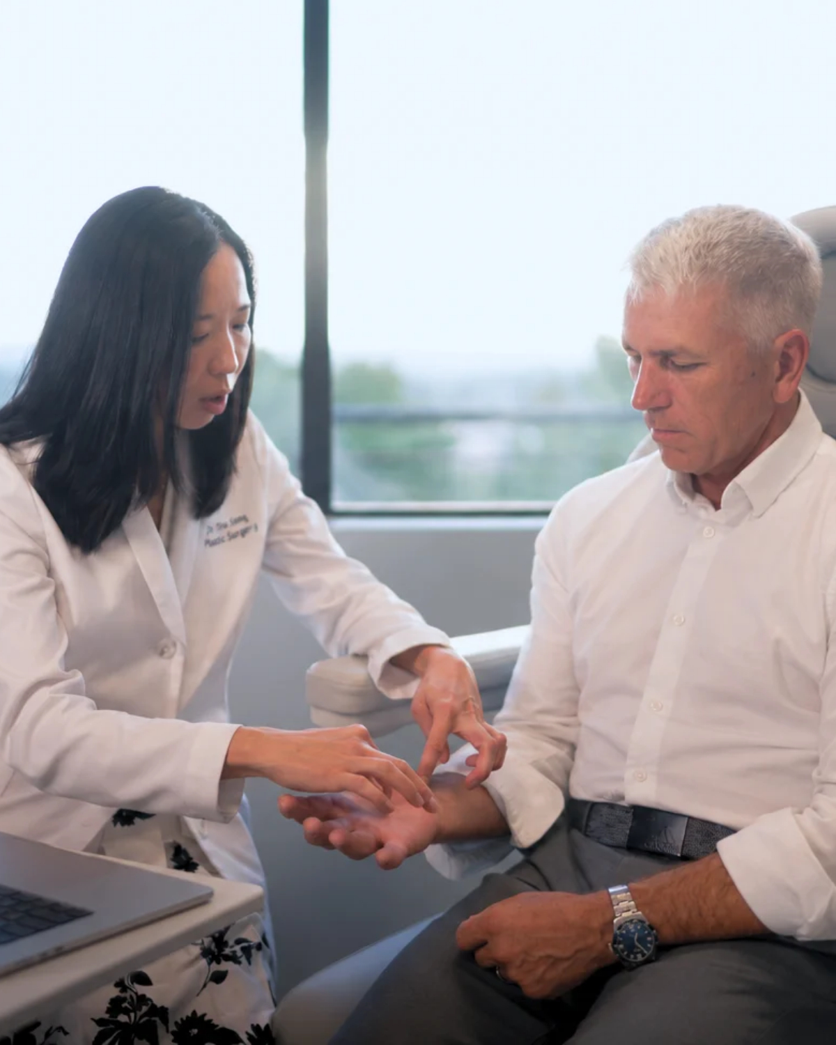 Dr. Tina Jenq examining a patient's hand at her Happy Valley clinic