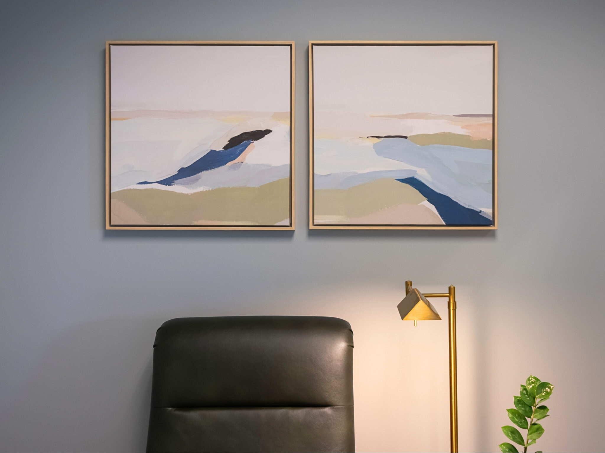 Seating area with framed landscape paintings and a brass lamp at Dr. Tina Jenq's clinic